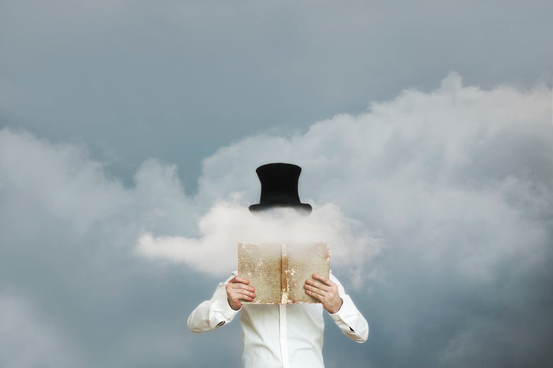 Surreal reader reading a book in the clouds that hide his face